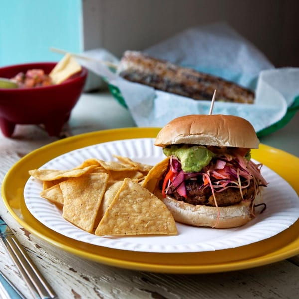 La Lupe Cantina's Mexican burger with guacamole, pickled cabbage, and tortilla chips.